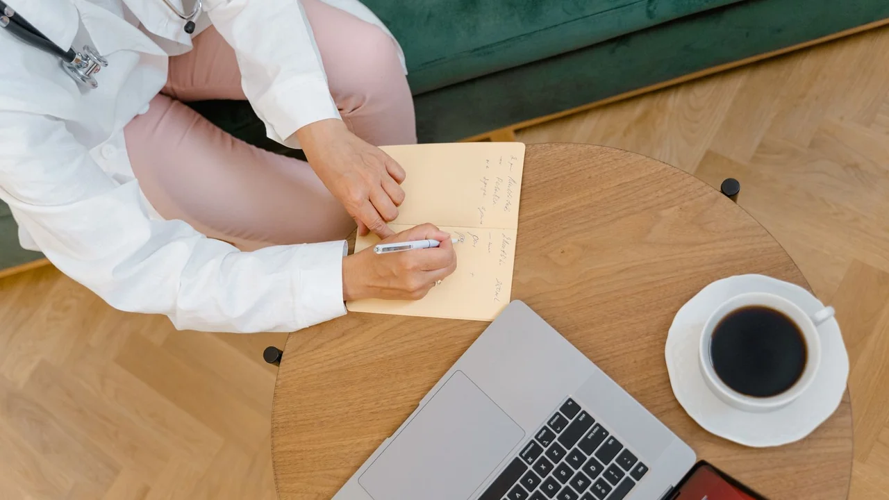 An overhead view of a notebook beside a laptop